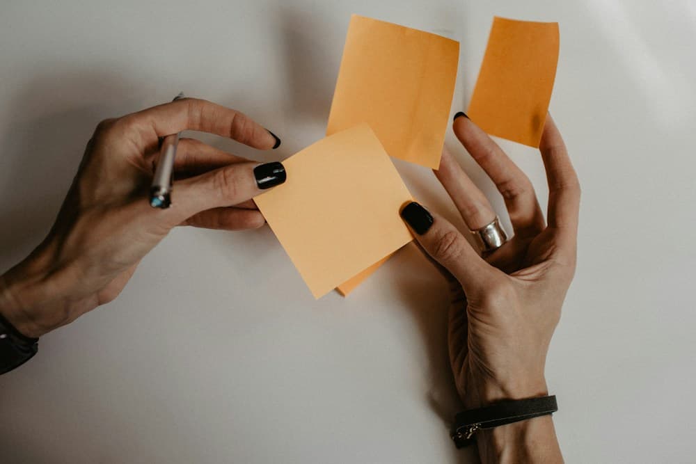 Hands arranging ideas on sticky notes